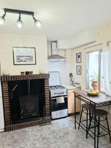 a kitchen with a fireplace and a table and a stove at Casa de la abuelita in Cazorla