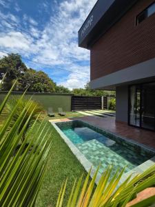 a swimming pool in front of a house at Casa Luar de Pitinga in Arraial d'Ajuda