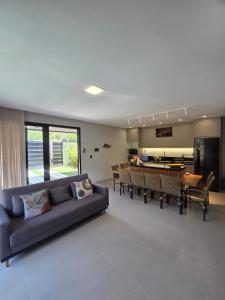 a living room with a couch and a dining room at Casa Luar de Pitinga in Arraial d'Ajuda