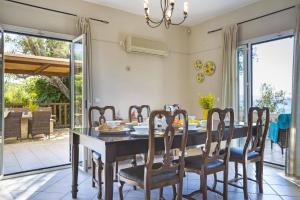 a dining room with a table and chairs at Villa Lourdas Beach by Villa Plus in Trápeza