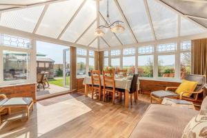 a conservatory with a dining room with a table and chairs at 3 Bed in Walcott oc-2135 in Walcott
