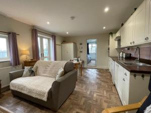 a living room with a couch and a kitchen at Stag Cottage in Ilkeston