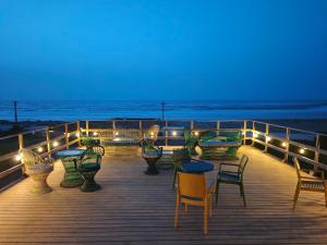 a deck with tables and chairs and lights on the beach at The Mogador's Oasis in Akermoud