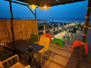 a deck with tables and chairs on the beach at The Mogador's Oasis in Akermoud +10 photos