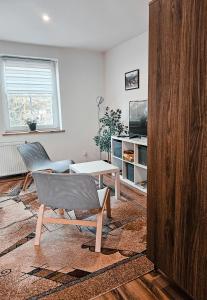 a living room with a table and a chair at Apartament 5 minut od Parku Zamkowego in Pszczyna