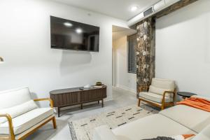 a living room with white furniture and a tv at Park Hotel 1BR Suite 410 in Chattanooga +20 photos