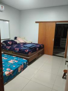 a bedroom with a bed and a wooden cabinet at Paraíso do aconchego in Aparecida de Goiânia +3 photos
