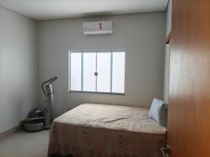 a bedroom with a bed and a window at Paraíso do aconchego in Aparecida de Goiânia
