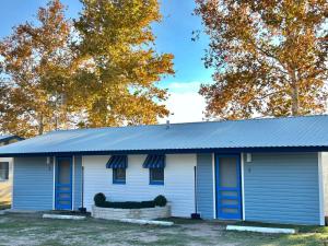 a white house with a blue roof at Oasis Lake Buchanan in Bluffton
