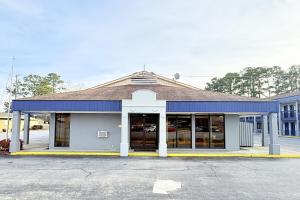 a store front with a blue and white building at OYO Hotel Williamston in Williamston +21 photos