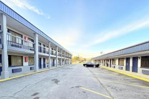 a car parked in a parking lot between two buildings at OYO Hotel Williamston in Williamston