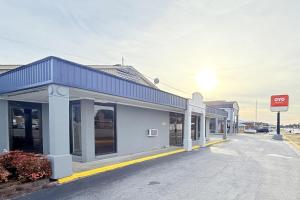 a building with a blue roof on a street at OYO Hotel Williamston in Williamston