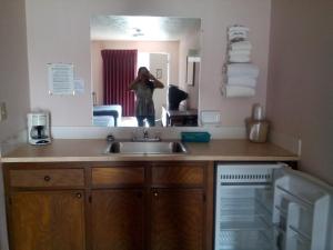 a person taking a picture of a kitchen mirror at Mountain Country Motor Inn in Branson West
