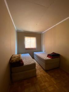 a small room with two beds and a window at Cabañas Donde Nancy in Hornillos