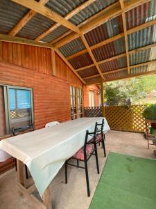 a large white table on a patio with two chairs at Cabañas Donde Nancy in Hornillos