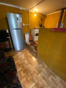 a kitchen with a refrigerator and a wooden floor at Cabañas Donde Nancy in Hornillos