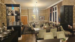 a restaurant with tables and chairs in a room at Mercure Darlington King's Hotel in Darlington