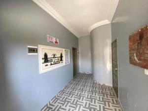 a room with a hallway with a painting on the wall at Résidence Le Petit Manoir in Cotonou