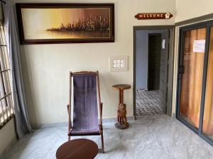 a room with a chair and a picture on the wall at Résidence Le Petit Manoir in Cotonou