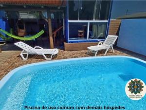 two chairs and a swimming pool in front of a house at Hospedagem Tribos Livres in Torres +19 photos