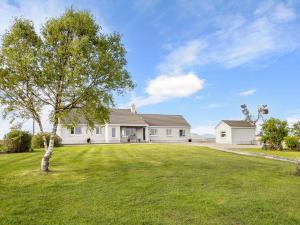 a white house with a tree in the yard at 3 Bed in Cashel oc-a32863 in Glinsk