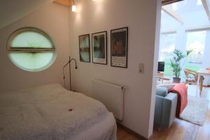 a bedroom with a bed and a window and a couch at Ferienhaus Kastaniengrün in Worpswede