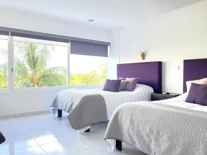 a bedroom with two beds and a large window at Divine Suite Cancun - BEACH CONDO - 6PX in Cancún