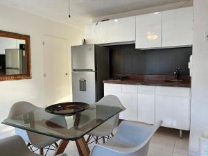 a kitchen with a glass table and white cabinets at Divine Suite Cancun - BEACH CONDO - 6PX in Cancún