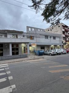 a building with cars parked in front of a street at Apto centro 03 in Tubarão