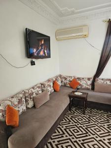 ein Wohnzimmer mit Sofa und Fernseher an der Wand in der Unterkunft Marrakech in Marrakesch
