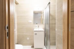 a bathroom with a sink and a shower at Trajadinha do Lima Rooms in Ponte de Lima
