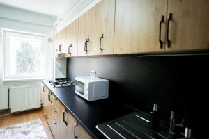 a kitchen with a microwave on a black counter at Apartament centru in Râmnicu Vâlcea