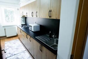 a kitchen with a sink and a microwave at Apartament centru in Râmnicu Vâlcea +32 photos
