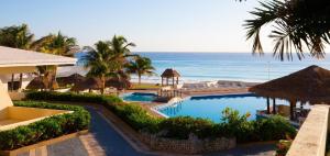 a resort with a swimming pool and the ocean at Divine Suite Cancun - BEACH CONDO - 6PX in Cancún