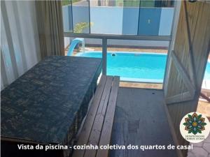 a bedroom with a bed and a swimming pool at Hospedagem Tribos Livres in Torres