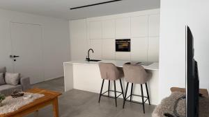 a kitchen with a counter and two bar stools at The 996 Business Flat in Lommel