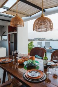 a wooden table with plates of food and wine glasses at Ola in San Carlos