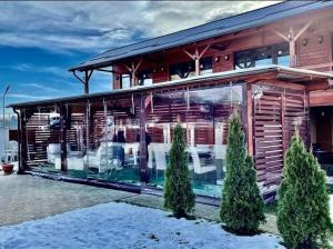 a house with a large glass facade in the snow at Casa David Turda in Turda