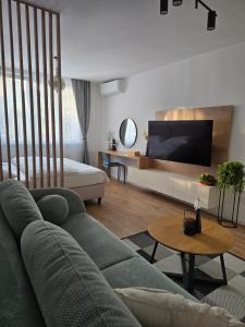 a living room with a couch and a tv at Apartmány Baťovany in Partizánske