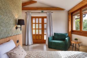 ein Schlafzimmer mit einem Bett und einem grünen Stuhl in der Unterkunft Sobe Rafut in Nova Gorica
