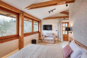 ein Schlafzimmer mit Bett, Stuhl und Fenstern in der Unterkunft Sobe Rafut in Nova Gorica