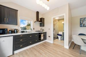 a kitchen with black cabinets and a dining room at The Meadows at Marlhill in Tipperary