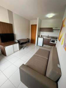 a living room with a couch and a kitchen at Privê Boulevard Suíte Hotel - 706 - Caldas Novas GO in Caldas Novas