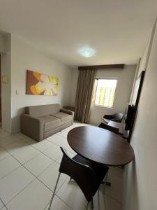 a living room with a table and a couch at Privê Boulevard Suíte Hotel - 706 - Caldas Novas GO in Caldas Novas