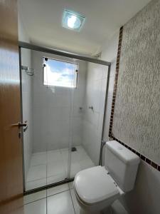 a bathroom with a shower and a white toilet at Privê Boulevard Suíte Hotel - 706 - Caldas Novas GO in Caldas Novas +8 photos