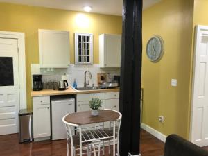 a kitchen with a table and a clock on the wall at Black Sheep Inn in Hammondsport