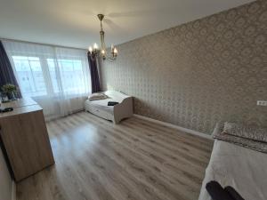 a room with a bed and a dresser in it at Butas in Mažeikiai