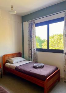 a bedroom with a bed and a large window at Forty Columns flat in Paphos