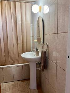 a bathroom with a sink and a mirror and a tub at Forty Columns flat in Paphos +18 photos