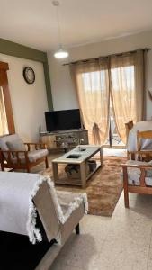 a living room with a couch and a table and a tv at Forty Columns flat in Paphos
